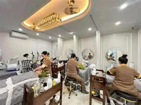 Kỹ thuật viên thực hiện chăm sóc da trong phòng spa có nhiều giường dịch vụ.