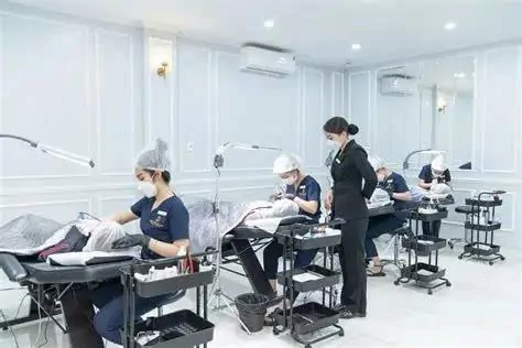 Giảng viên quan sát học viên thực hành chăm sóc da trên người mẫu.
